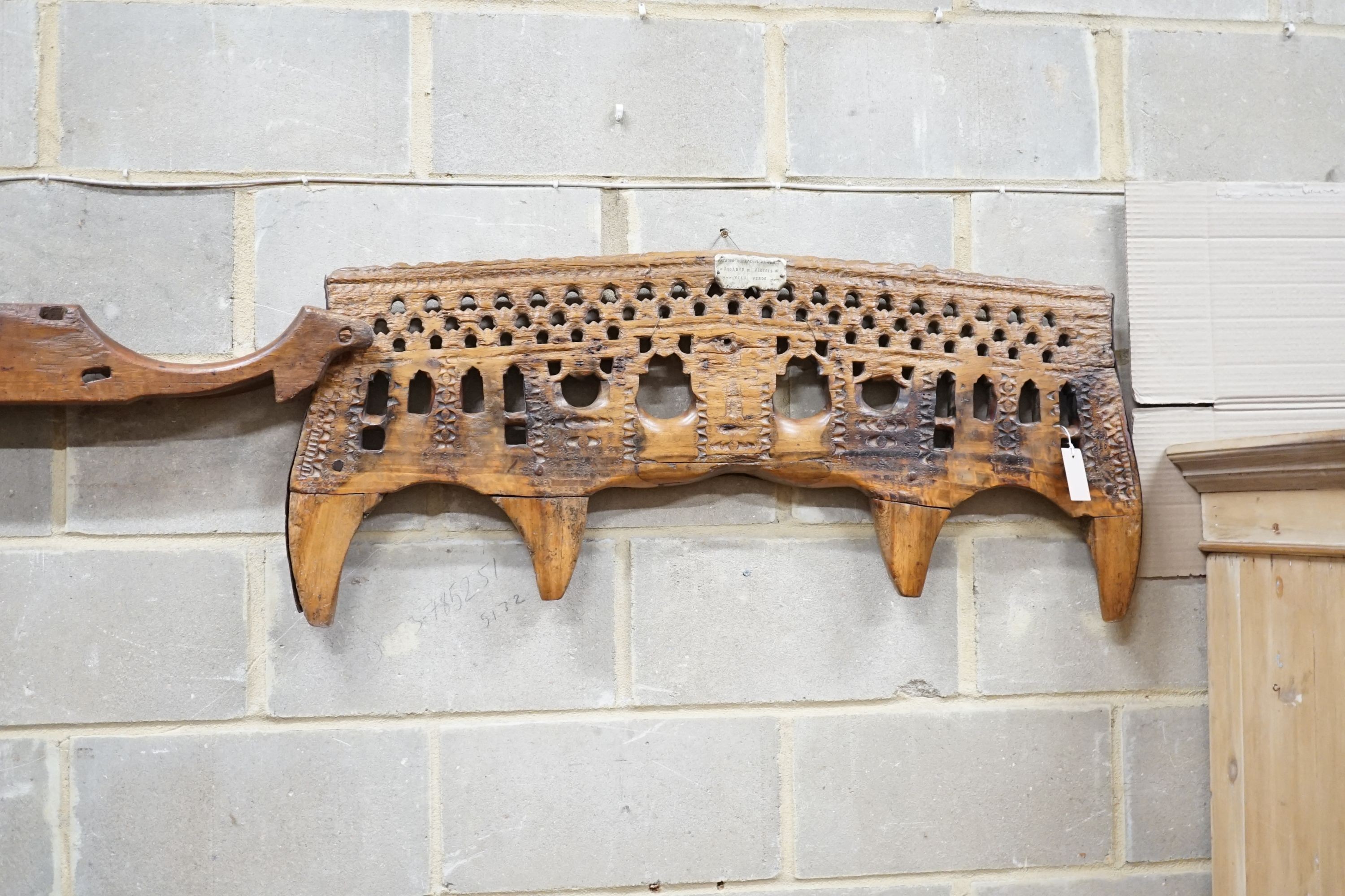 A carved hardwood ox yoke with plaque inscribed Antonio Gonzalez Vila Verde, width 110cm and another plainter yoke, width 111cm